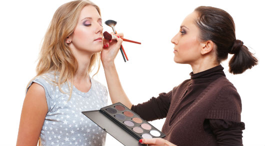 Maquiadora fazendo texturas com o blush no rosto da cliente