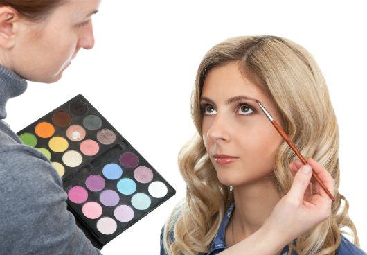 Maquiadora retocando a sobrancelha da cliente