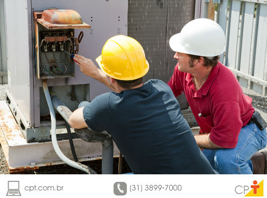 Consumo de energia em edifícios - saiba como controlar técnicos avaliando um aparelho de ar-condicionado